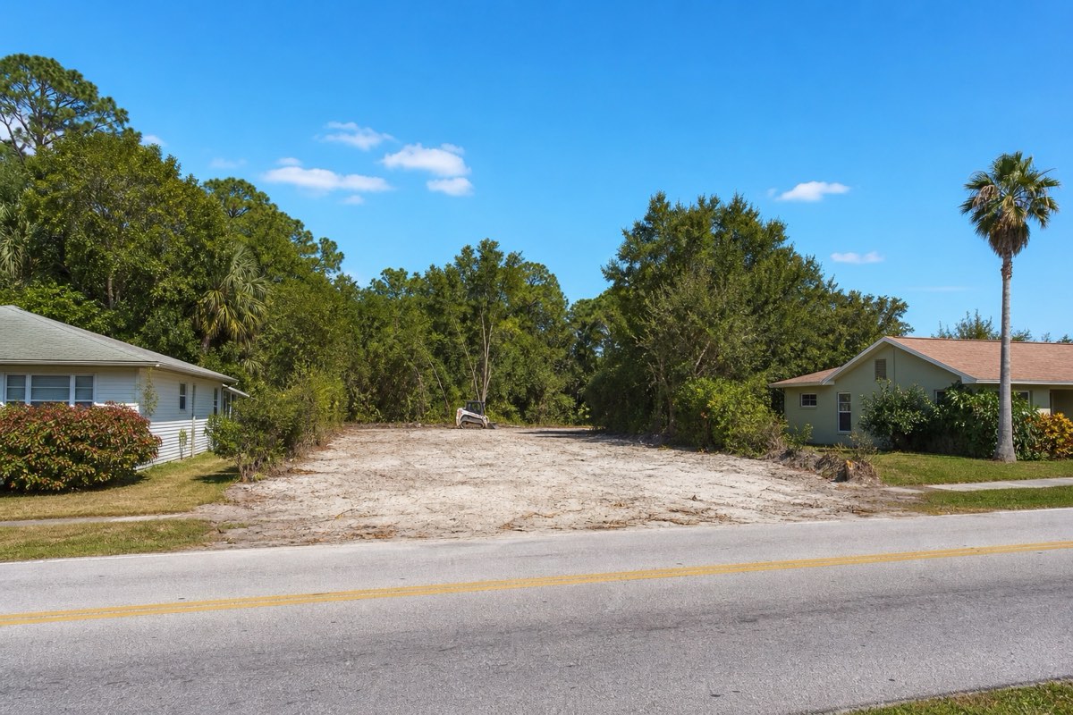 Wooded infill lot being cleared between two occupied houses on a residential street in Rockledge