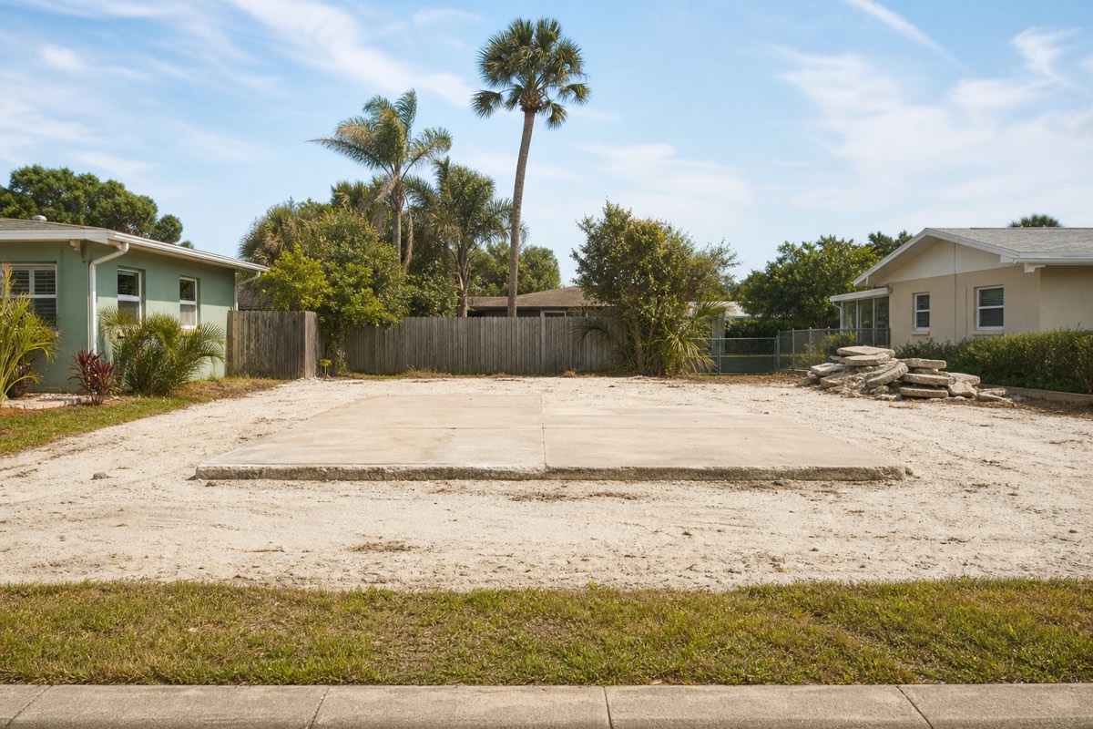 Cleared rebuild lot with fresh stump grindings between two existing beachside homes in Satellite Beach